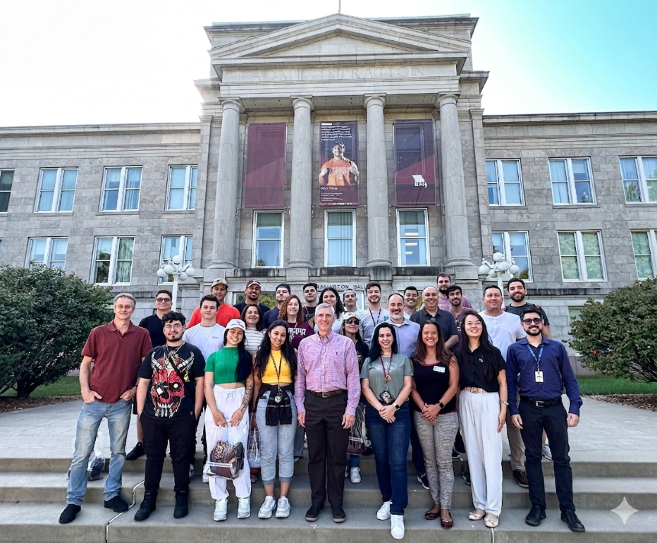 A group of students and faculty, featuring Vice President Brad Bodenhausen at the center, pose on the steps of Carrington Hall at Missouri State University.
