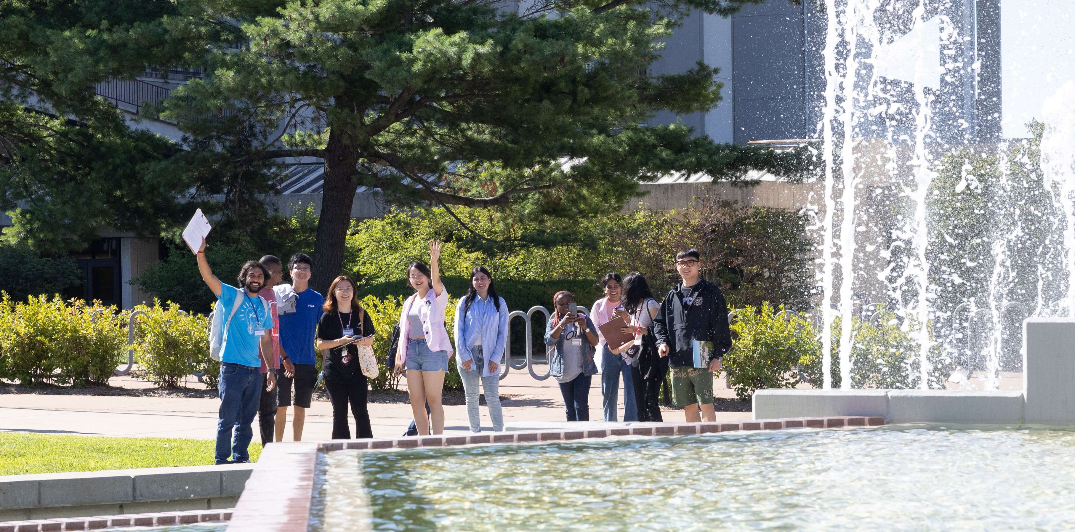 Students standing next to the fountain exploring campus 